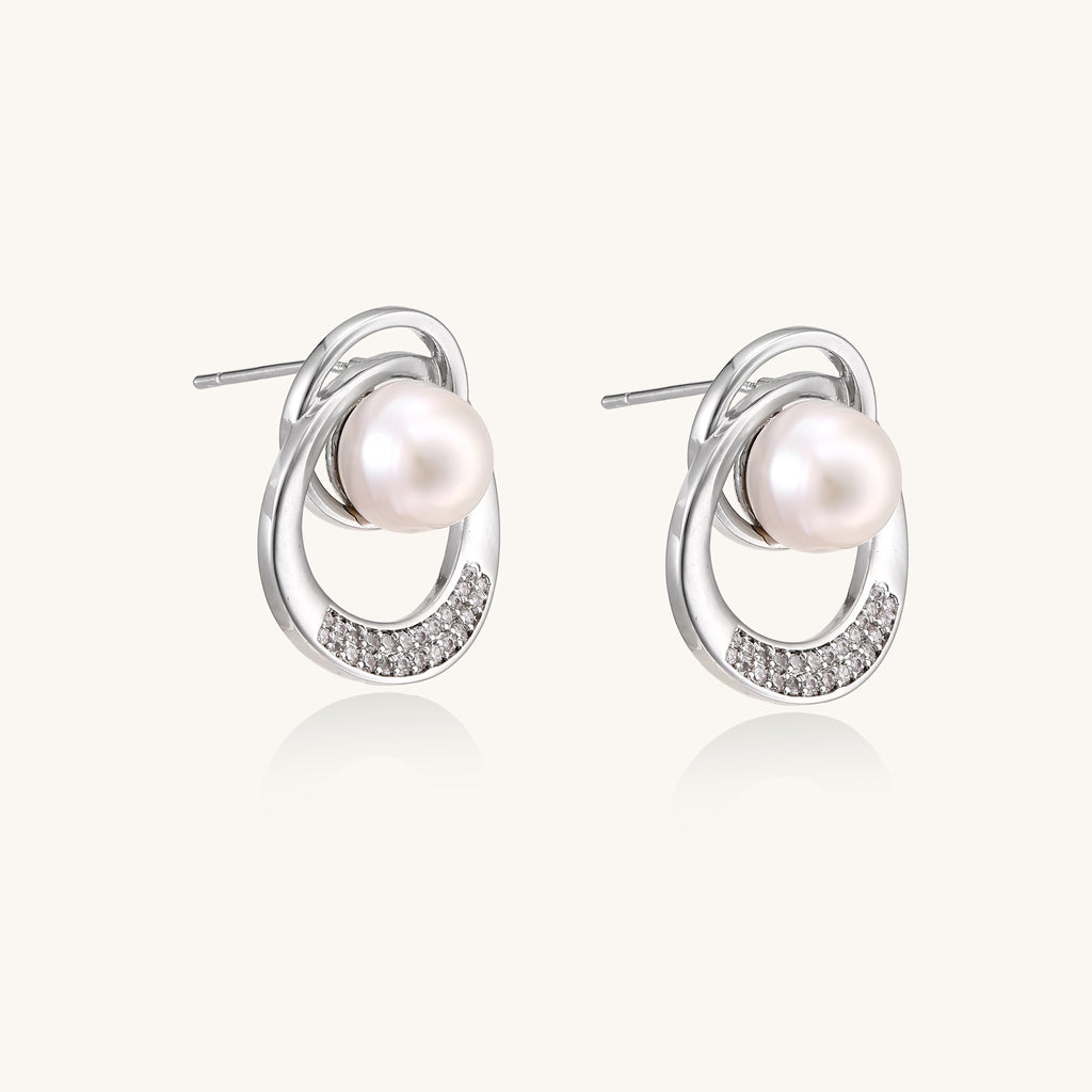 Gold-plated brass stud earrings with swirled circular design holding white freshwater pearls and small crystals