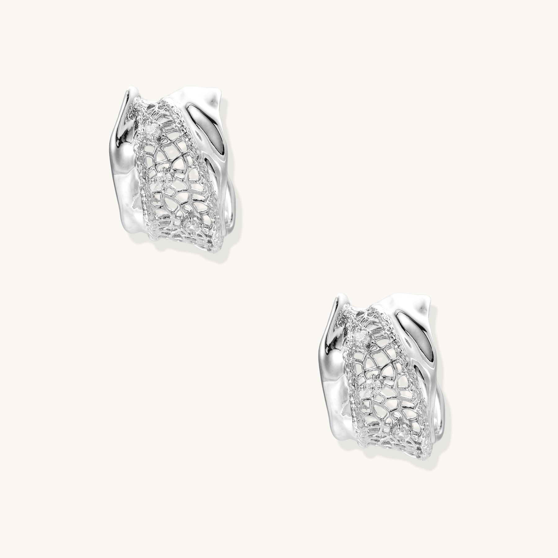 Small gold-plated brass hoop earrings with geometric lattice pattern and zirconia accents on white background.