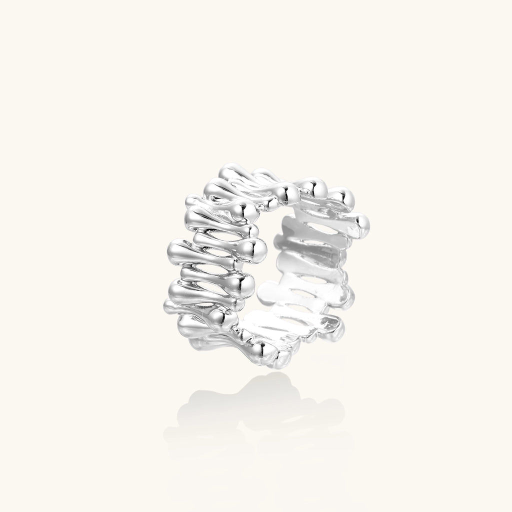 Close-up of an artistic gold-plated brass ring with multiple twisted bands creating a sculptural flowing design