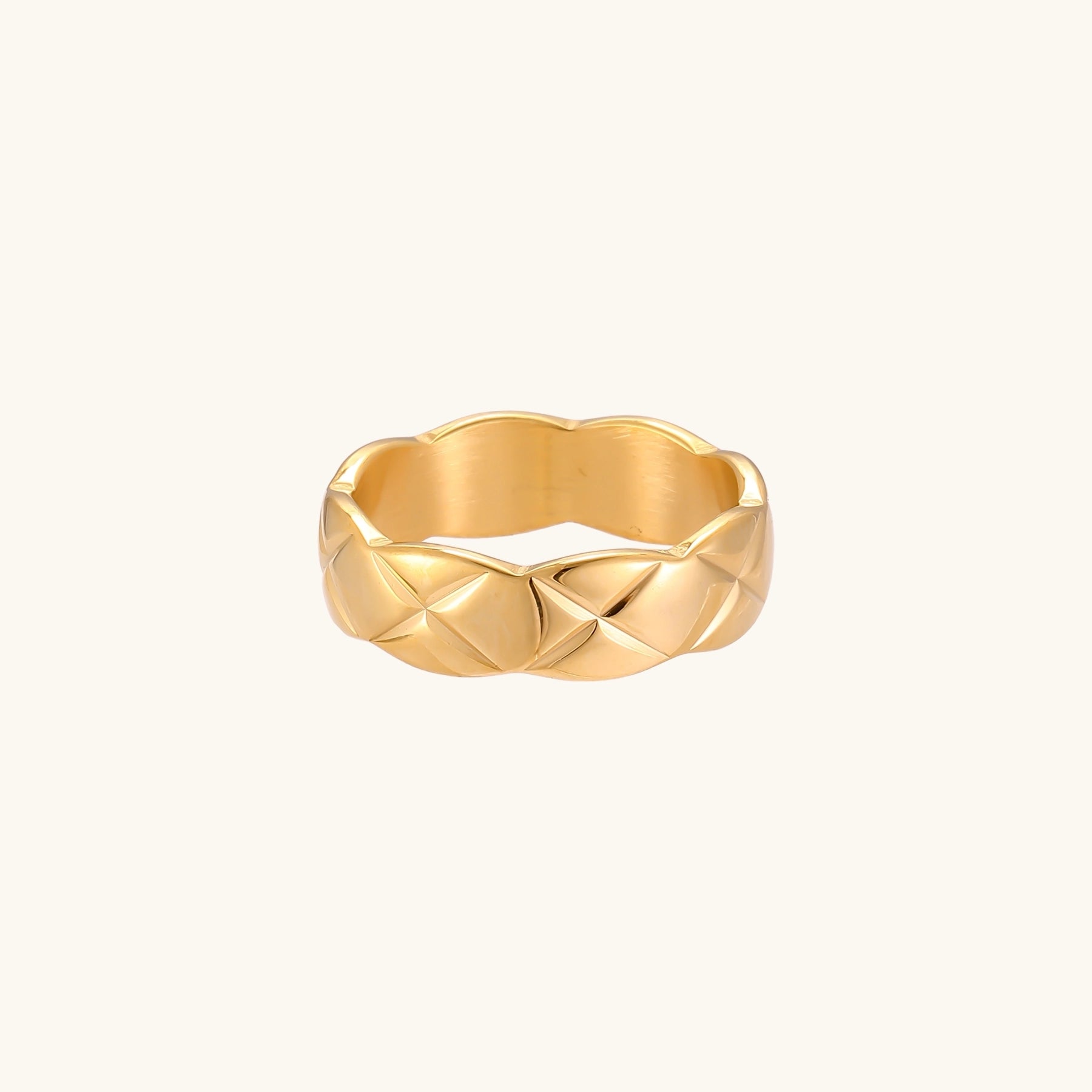 18K gold plated stainless steel ring with geometric twisted band design on neutral background