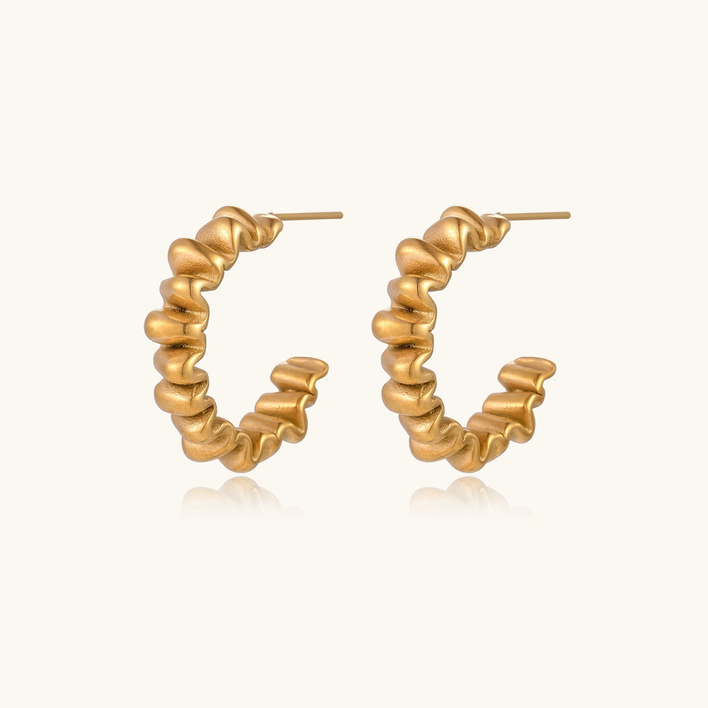 Gold-plated stainless steel earrings with twisted rope texture in various hoop sizes on neutral background.